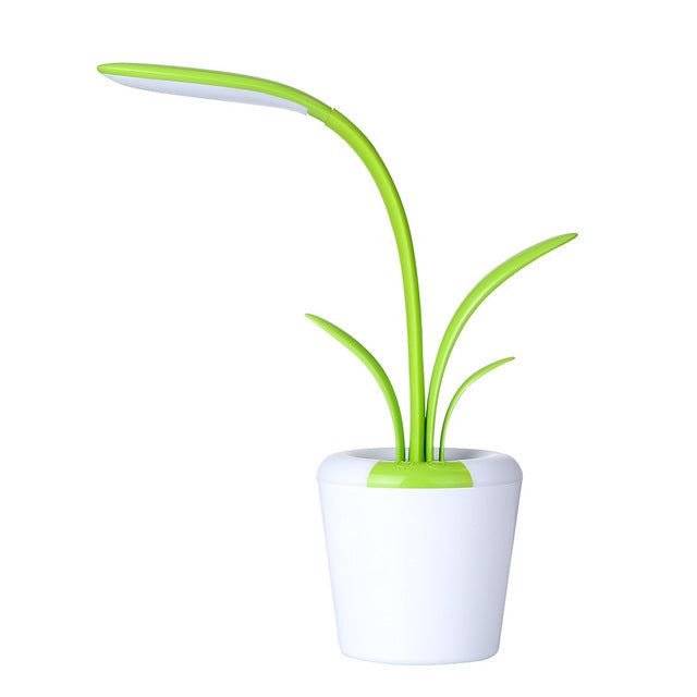 Green plant-shaped lamp with white base on a white background