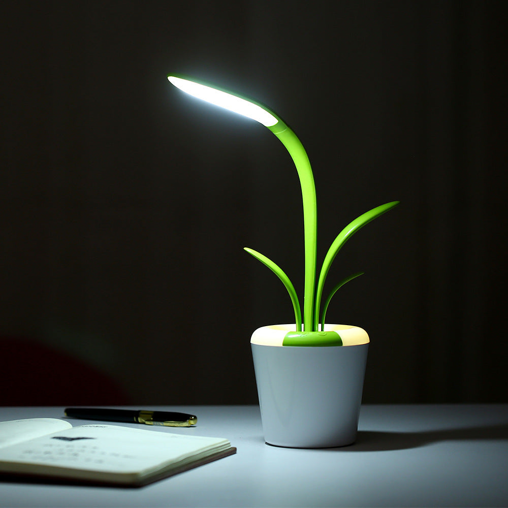 Potted plant-shaped desk lamp on a dark background