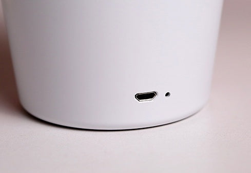 Close-up of a white electronic device with a USB-C port on a light background