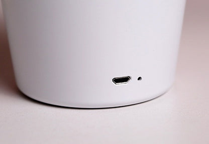 Close-up of a white electronic device with a USB-C port on a light background