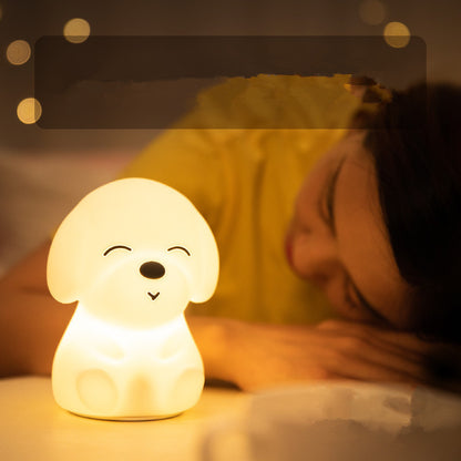 Dog-shaped night light on a surface with a blurred person in the background